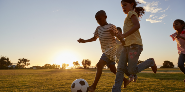 Criança jogar futebol junto com o amigo